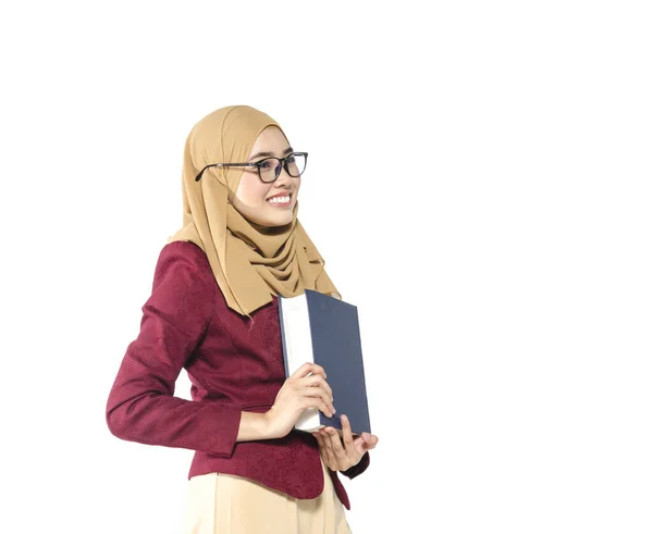 Confident young woman with hijab standing and holding book on white background. — Stock Photo, Image
