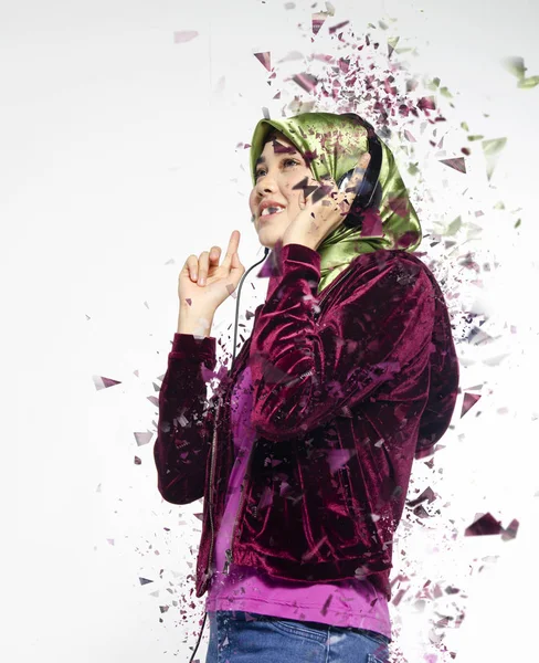 Captura de estudio, retrato de jóvenes bellos musulmanes asiáticos usando hijab escuchando música con auriculares —  Fotos de Stock