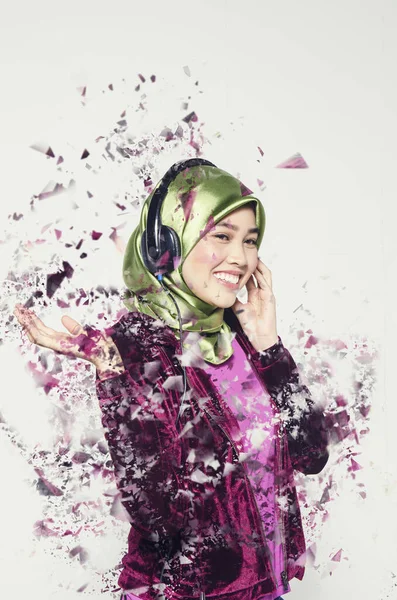 Studio shot, potret muda muslim Asia yang cantik mengenakan jilbab mendengarkan musik dengan headset — Stok Foto