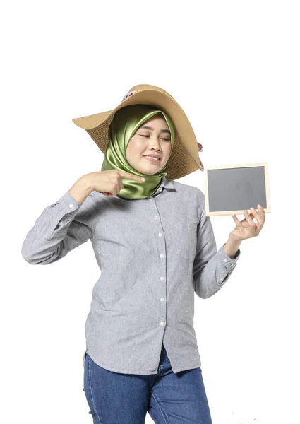 Beautiful lady with hijab standing and holding blank chalkboard for text. — Stock Photo, Image