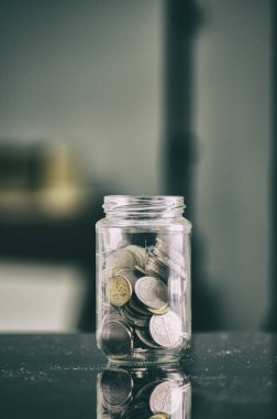 financial concept,coin in transparent glass jar over shallow depth of field background 