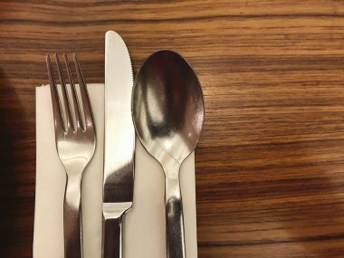 fork and silver spoon on wooden table