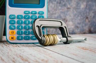 Finansal kriz konsepti, hesap makinesi ve para istifleme tahtaya G-klemp sıkıştırma 