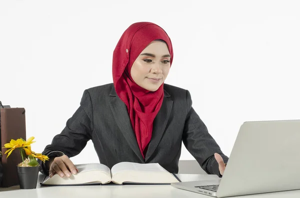 年轻的女商人或戴头巾的女学生坐着 用白色背景看她的笔记本电脑 — 图库照片