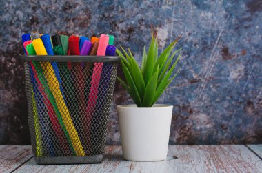 Okula ve ofislere geri dönüş, sabit konsept, koyu arkaplan üzerine metal bir kutuda renkli kalem işaretleri yığını