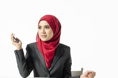 İletişim konsepti, tesettürlü genç bir kadın beyaz arka plandaki cep telefonuyla arkadaşlarını aramaya başlıyor.