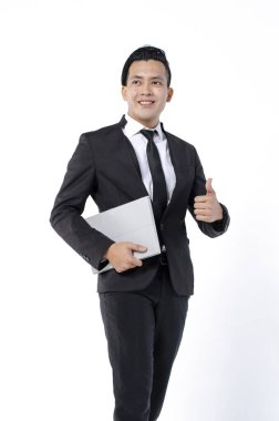 Siyah takım elbiseli genç iş adamı beyaz arka planda tablet tutuyor.