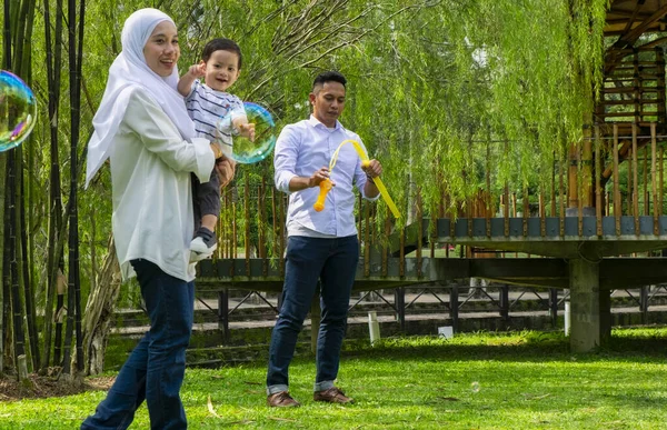 부모들은 주말에 자녀들 공원에서 시간을 보내면서 가족적 개념을 가지고 — 스톡 사진
