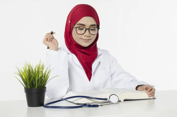 Genç bayan doktor masasında otururken vizyonunu ve kariyerini düşünüyor. 