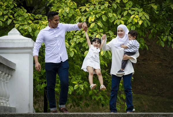 幸せな家族のコンセプト 若い両親は週末に公園で子供たちと時間を過ごす — ストック写真