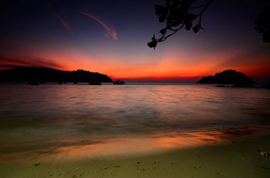 Perak Eyaleti, Malezya 'da yer alan Pangkor Adası' nı çevreleyen doğanın güzelliği günbatımında arka planda yer alıyor