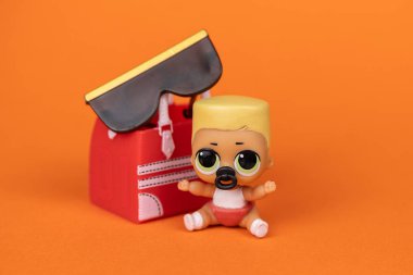 Bir LOL. Turuncu arka planda sürpriz bebek.