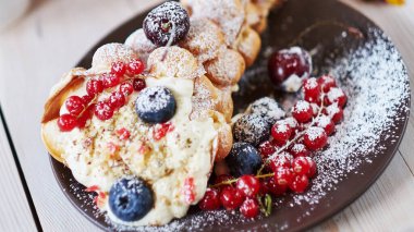 Tahta bir masada meyveli lezzetli balonlu waffle.