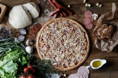 Köy usulü ahşap masada etli pizza.