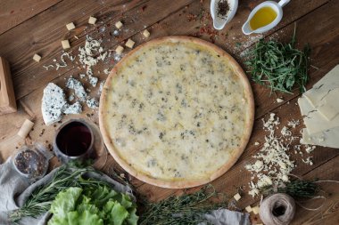 Köy usulü ahşap masada peynirli pizza.