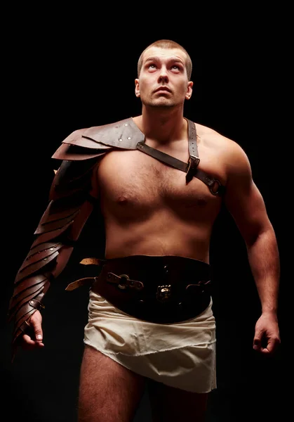Gladiador com espada e armadura sobre fundo preto — Fotografia de Stock