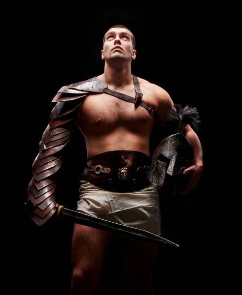 Gladiator with sword and armor on a black background — Stock Photo, Image