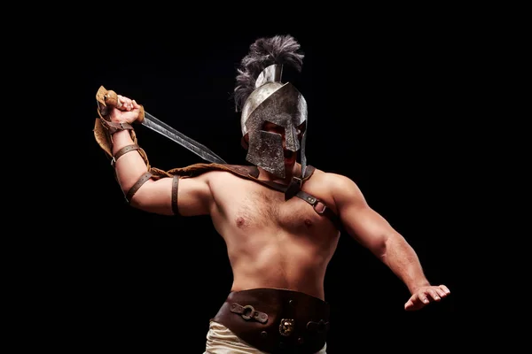 Gladiador com espada e armadura sobre fundo preto — Fotografia de Stock