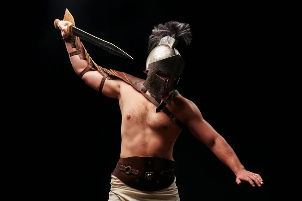 Gladiator with sword and armor on a black background — Stock Photo, Image