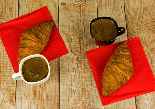 Croissants and coffee in cups — Stock Photo, Image
