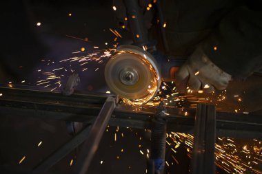 Metal kesimi. Metal bir profilin işlenmesinden kıvılcımlar.