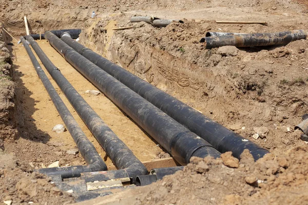 Pipes of underground utilities. Laying water pipes into the ground.