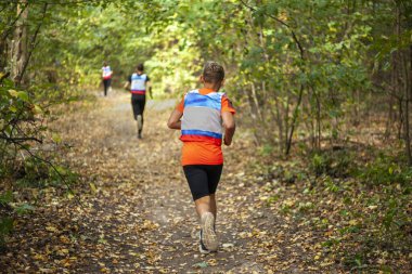 Koşu yarışması. Bir çocuk ormanda koşuyor..