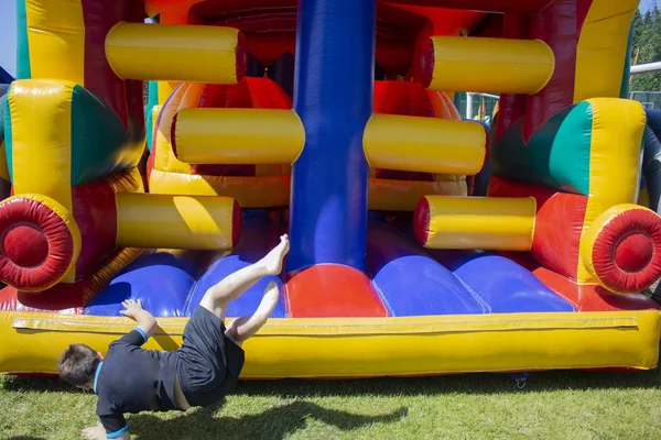 El niño se divierte en una estructura inflable. Zona de juego . —  Fotos de Stock