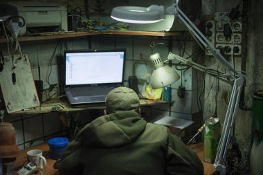 Hacker dizüstü bilgisayarın başında oturuyor. İnternetteki anonim kişi.