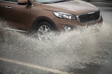 Araba bir su birikintisinin içinden geçiyor. Islak arabalar.