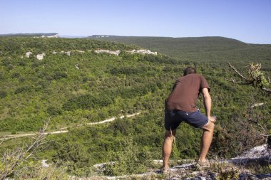 Adam bir kayanın üzerinde oturuyor. Turist kafası