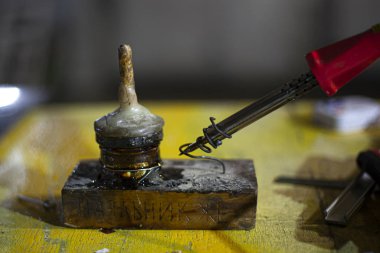 Kaynak makinası masada. Metal füzyonu için bir araç. Atölyede çalış. El işçiliği. Metali ısıtmak için elektrikli bir alet. Hobi lehim kabloları.