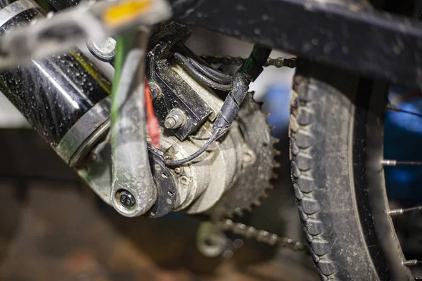 Electric bike close-up. Details of the bike. Gears and bike frame. A bicycle foreman is looking at what to repair in his vehicle.