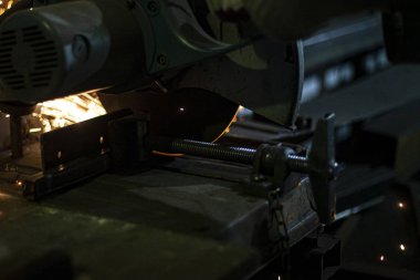 Metal kesimi. Öğütücü çelik. Öğütücü olarak çalış. Sürtünmeden kıvılcımlar çıkıyor. Erkek işi. Bir tasarım yaratıyorum. Atölyedeki proje. Demir işleme. El elektrikli aracı.