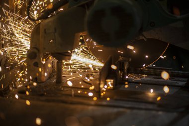 Metal kesimi. Öğütücü çelik. Öğütücü olarak çalış. Sürtünmeden kıvılcımlar çıkıyor. Erkek işi. Bir tasarım yaratıyorum. Atölyedeki proje. Demir işleme. El elektrikli aracı.