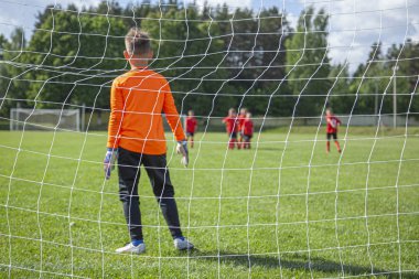 Kaleci topu yakalıyor. Hedefe odaklan. Spor müsabakası. Çocuk futbolu sahada. Fiziksel gelişim. Çocuk sporu. El çabukluğu. Top Şampiyonası.