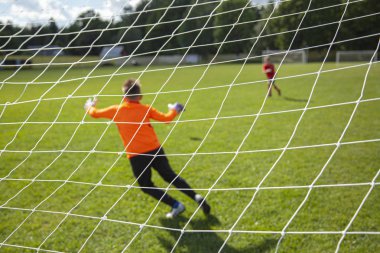 Kaleci topu yakalıyor. Hedefe odaklan. Spor müsabakası. Çocuk futbolu sahada. Fiziksel gelişim. Çocuk sporu. El çabukluğu. Top Şampiyonası.
