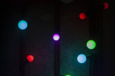 Renkli çelenkler karanlıkta aydınlanır. Parlak Leds. Popüler kültürün çok güzel bir geçmişi var. Dizayndaki gökkuşağının tüm renkleri. Dekorasyon için elektrikli ekipman.