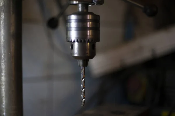 Drill for metal. Drilling machine is in the workshop. Handwork in the garage. An old cnc-free machine. Darkened room with tools. Men\'s work. making holes.