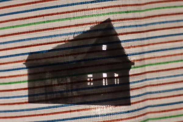 Carved cardboard house. The silhouette of the house on the fabric. An abandoned house with horrors. Night old house. Figurine made of paper. How to entertain a child. Shadow play. Animation without a computer.