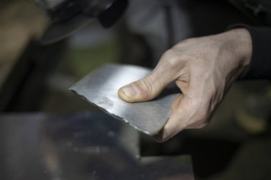 Metal kesimi. Öğütücü çelik. Öğütücü olarak çalış. Sürtünmeden kıvılcımlar çıkıyor. Erkek işi. Bir tasarım yaratıyorum. Atölyedeki proje. Demir işleme. El elektrikli aracı.