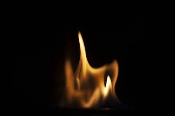 火爆的背景黑暗中的火光 火焰般的质感火舌平稳地升起 一个简单的黄色阴影背景 点火用的燃烧凝胶 蒸气的燃烧 火是危险的 — 图库照片