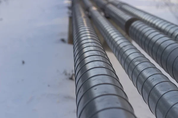 Pipes with hot and cold water. City communications. Metal pipes above the ground. Element of the water supply system.