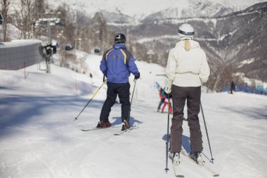 Bir kayakçı karlı bir yamaçta gezer. Kışın aktif dinlenme. Atlet iniş için hazırlanıyor. Dağ kayak merkezi. Kış tatilinde açık hava aktiviteleri. Sezonun en iyi zamanı. Kardan koruyan takım elbiseli bir adam..