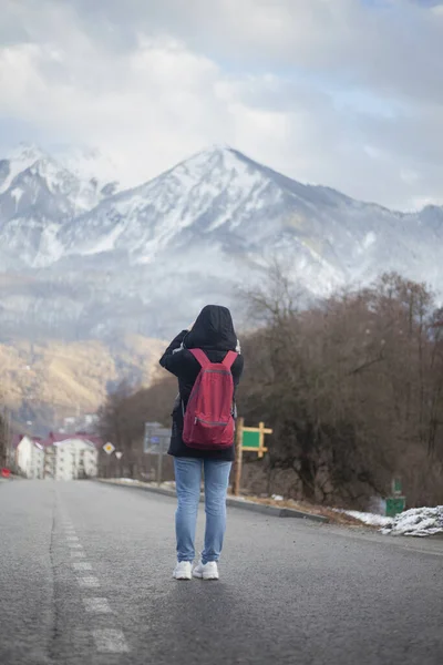 Una chica se para en un camino en las montañas . — Foto de Stock