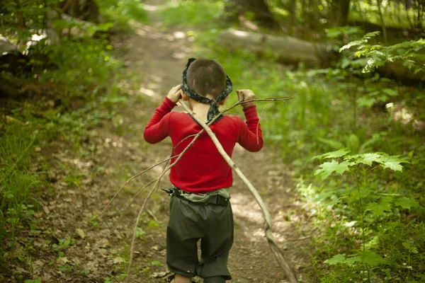 A child walks through the woods.