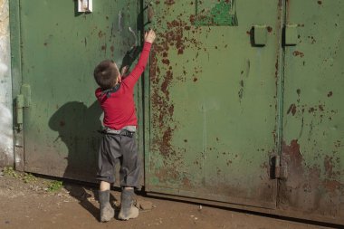 Sokakta oynayan bir çocuk.