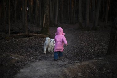 Çocuk bir köpekle yürüyor..