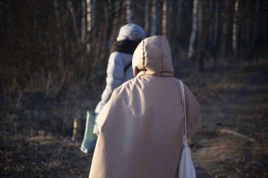 Kapüşonlu, büyük ceketli bir kız..