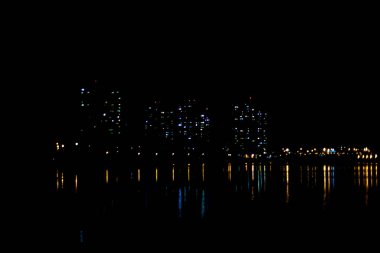Şehir ışıkları suya yansıyor..